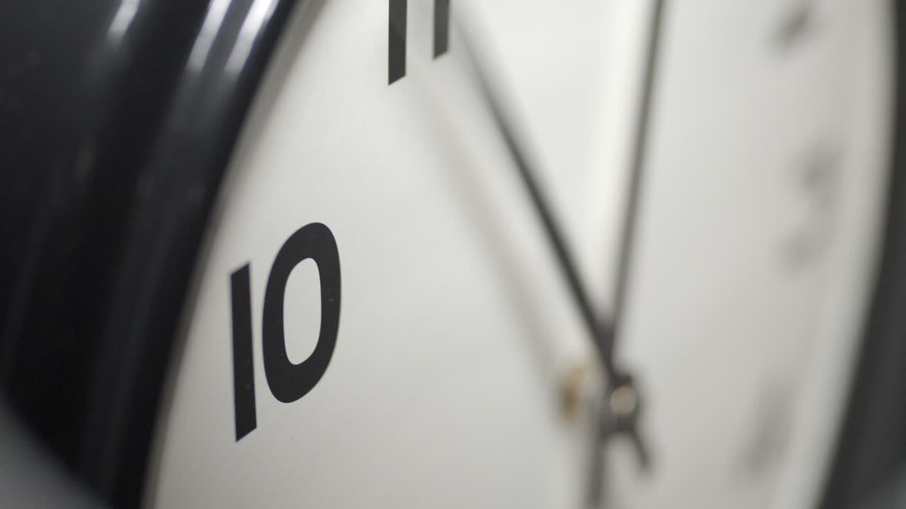 White Clock Face Close Up in Time Lapse on Dark Grey Wall