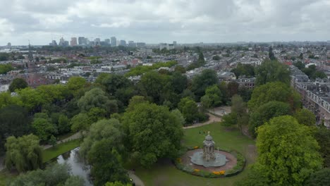 sarphatipark public park in amsterdam, forward aerial on cloudy day