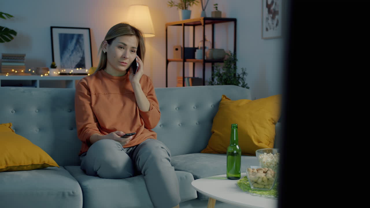 Woman Talking on Phone While Watching TV