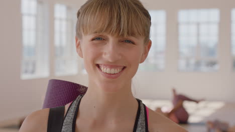 yoga class portrait of happy caucasian woman smiling confidently enjoying healthy lifestyle with multi ethnic people practicing in fitness studio background