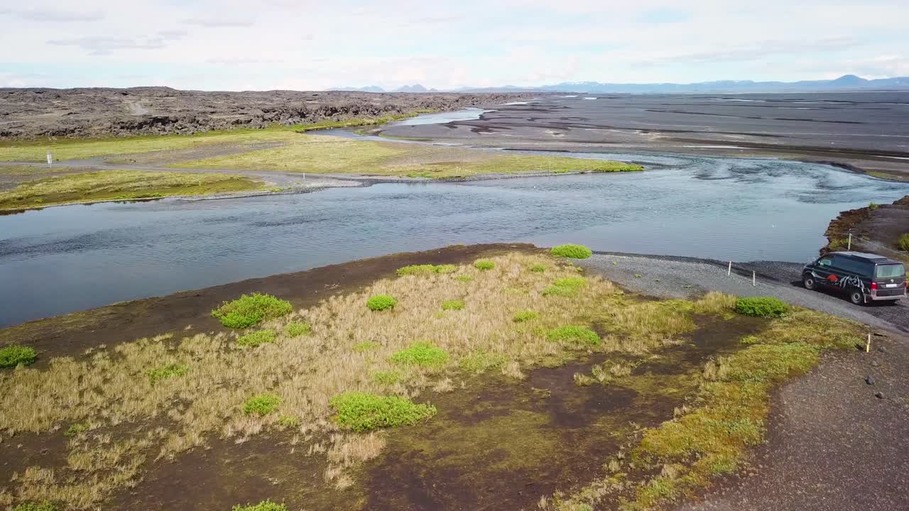 아이슬란드 고지대의 강을 가로지르는 검은색 밴 위의 공중
