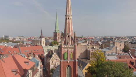 Riga-aerial-view-of-St-Saviours-Anglican-church-on-sunny-day,-rising-above-cross-tower,-Latvia