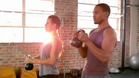 fit couple lifting kettlebells together