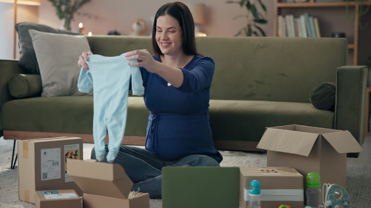 Pregnant woman unpacking baby clothes from online delivery