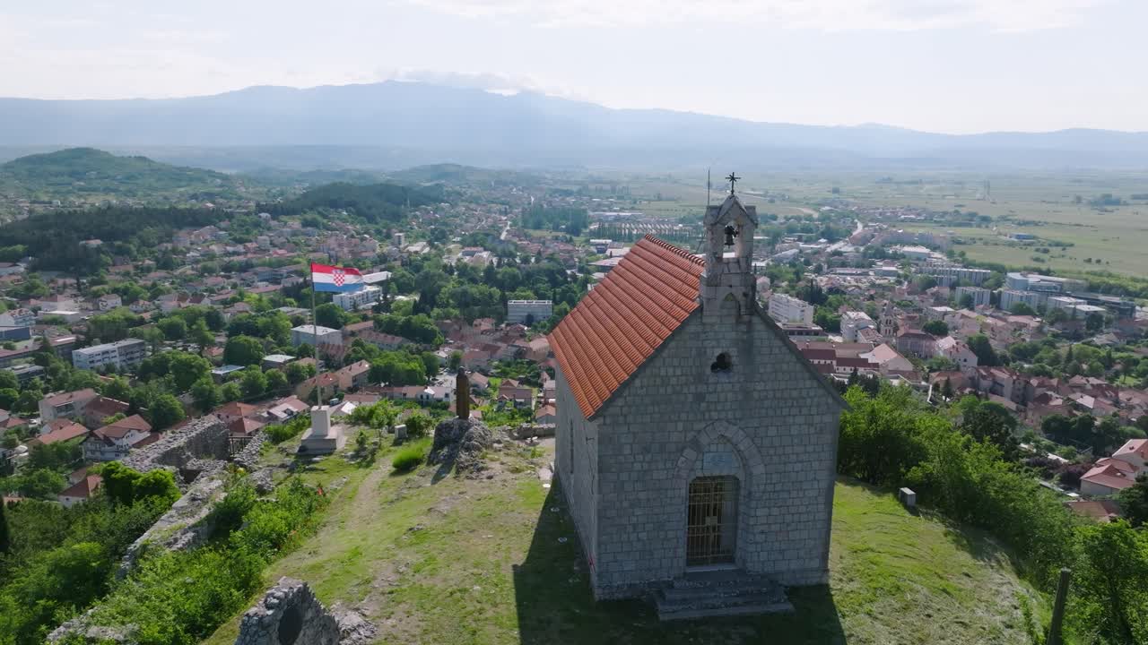 vista aérea de la fortaleza en la cima de la montaña y el casco antiguo de sinj, croacia