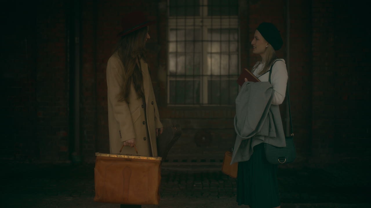 두 명의 웃는 여성들이 이야기하고 있습니다.