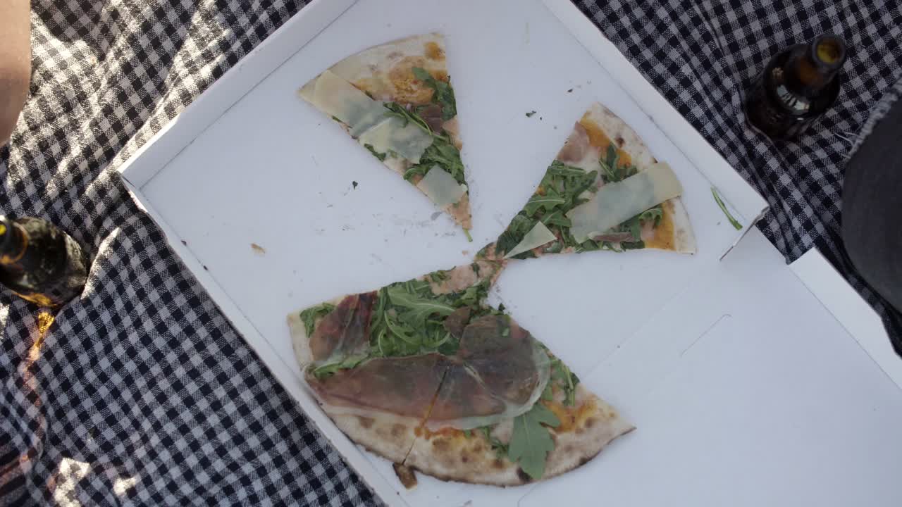 amigos comiendo pizza en un picnic