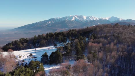 aerial drone shot mount olympus winter snow fly over forest foreground