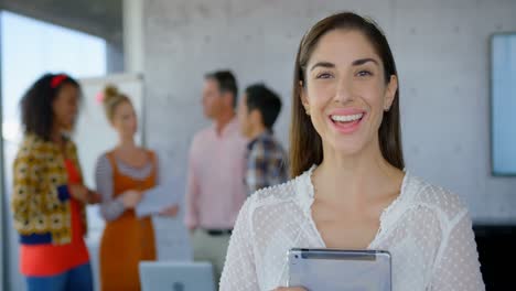 mujer caucásica feliz sosteniendo una tableta digital y mirando la cámara 4k