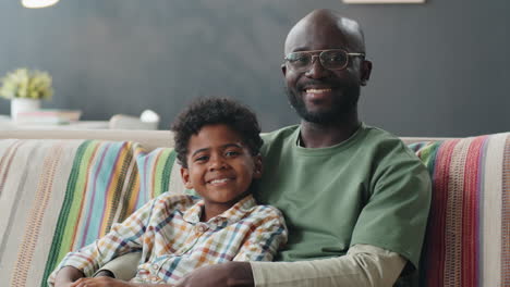 Portrait-of-Happy-African-American-Father-and-Son-on-Sofa-at-Home