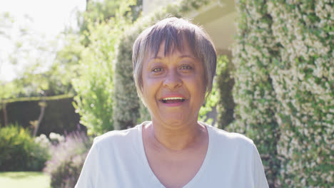 Retrato-De-Una-Feliz-Mujer-Birracial-Mayor-Sonriendo-Y-Riendo-En-El-Jardín,-En-Cámara-Lenta