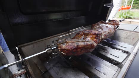 Rotisserie-meat-spread-across-gas-grill-rotates-dark-brown,-perfect-char