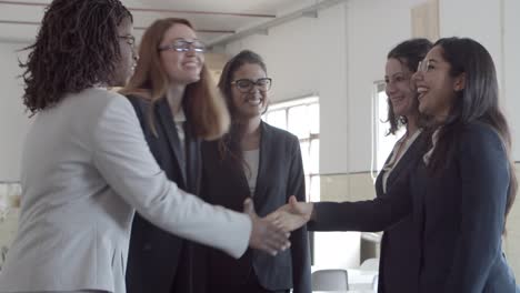 Mujeres-Empresarias-Sonrientes-Saludándose-En-La-Oficina