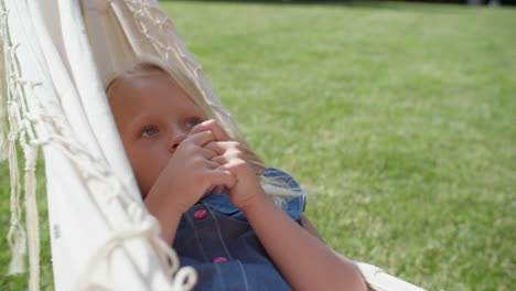 child girl relaxing in hammock outdoors