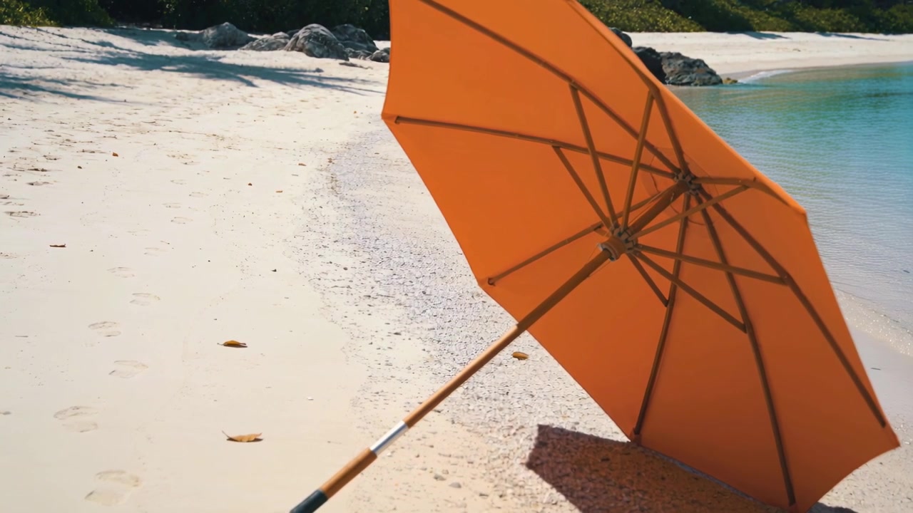 Operatør skubber dolly, bevæger sig tættere til højre, indrammer orange paraplyribber og stang på solbeskinnet strand