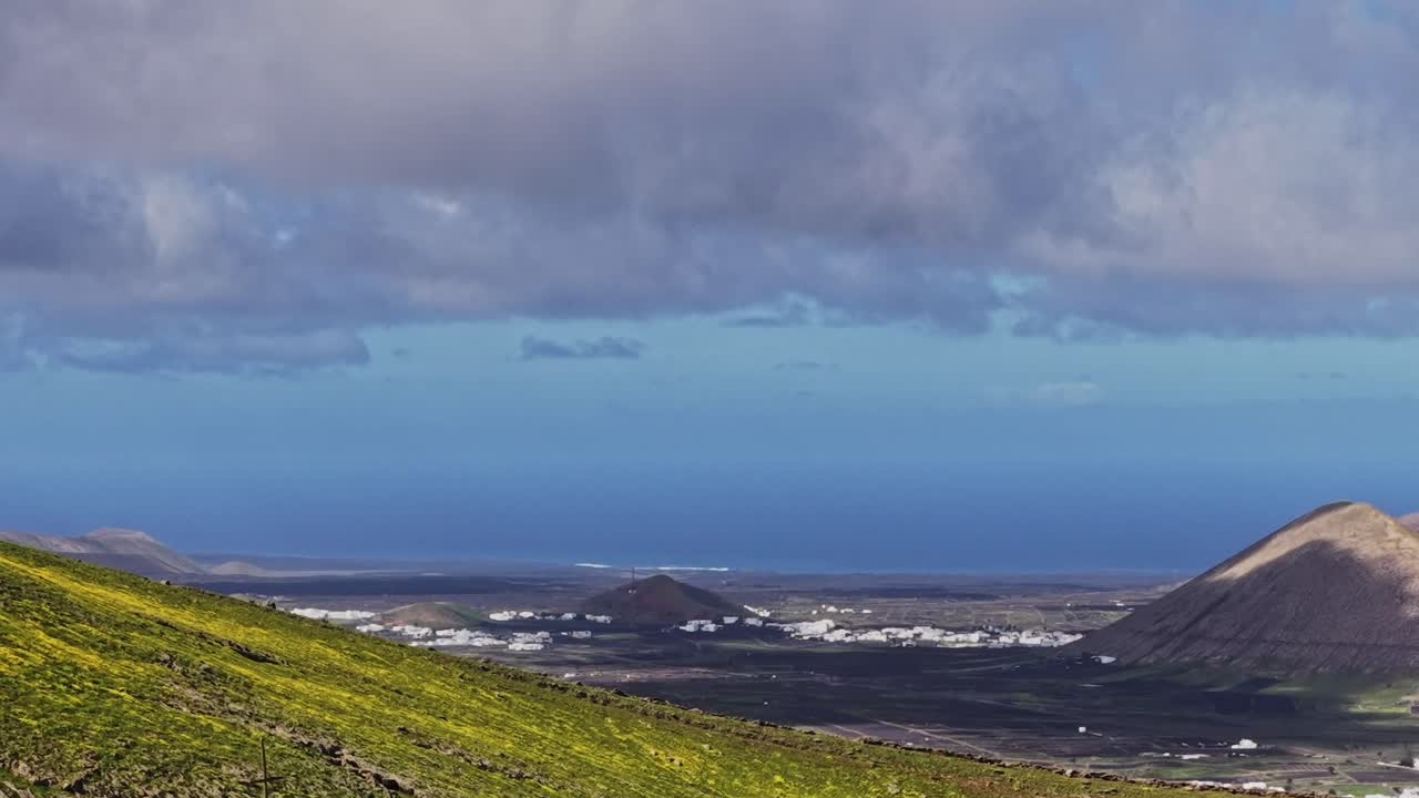 Paesaggio verde lussureggiante sulla costa di Lanzarote con vista sull'oceano e nuvole