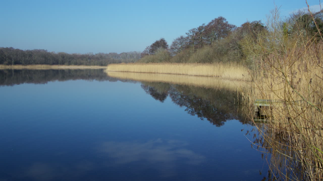 Long shot of Rollesby Broad with sky reflecting in the water taken from the A149 at Ormesby St Margaret