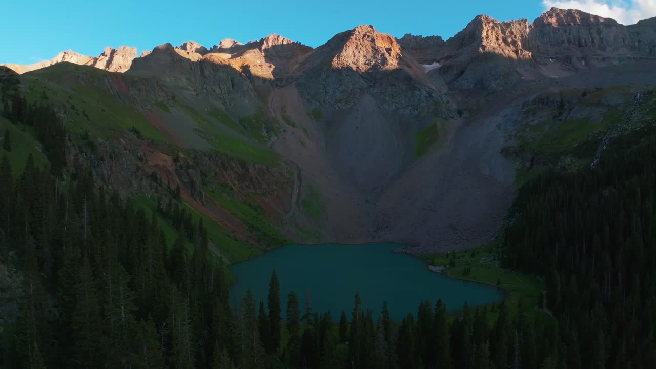 Sunset dusk Lower Blue Lake Mount Sneffels Wilderness Ridgway Telluride Colorado aerial drone golden hour shaded peaks San Juan Rocky Mountains Uncompahgre National Forest last sunlight circle pan up