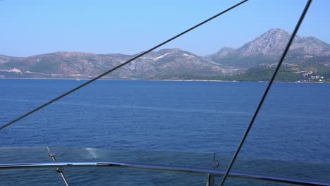 blue sea and coastal mountain seen from sailing yacht on a summer day