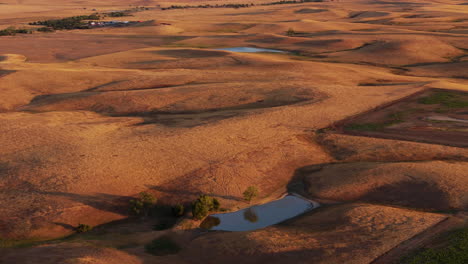 aerial view of a sunny, dry prairie landscape with ponds