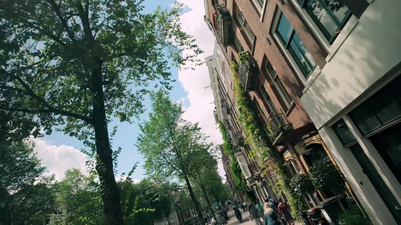 A sunny day in Amsterdam: Walking along a canal-side street