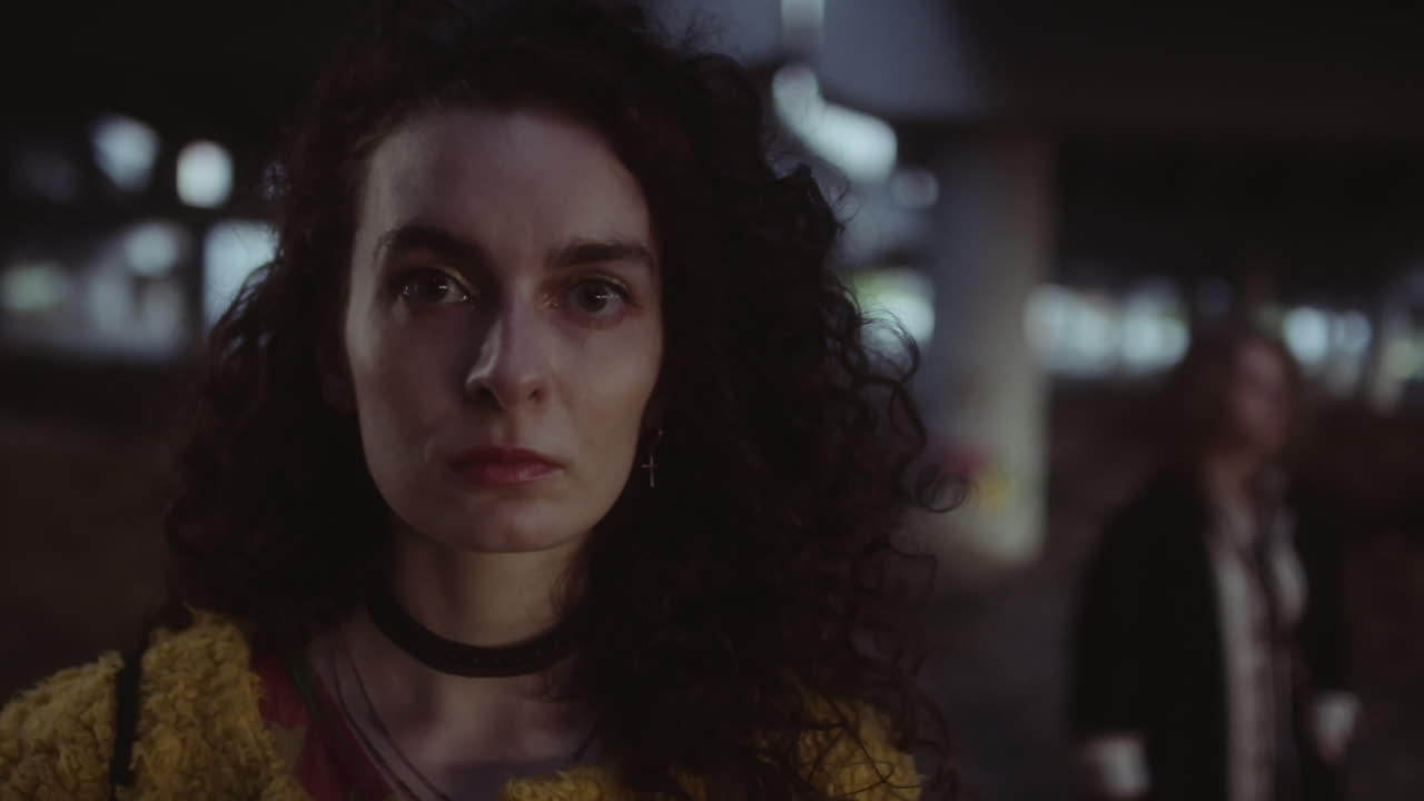 Portrait of a woman with curly hair in a dark urban setting