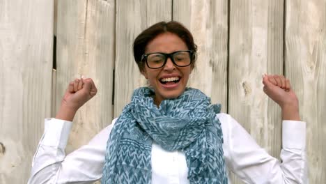 hipster cheering against wooden fence