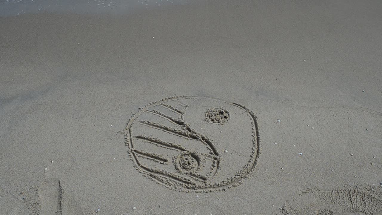 Yin e Yang sulla sabbia, in spiaggia. Scatto in spiaggia.