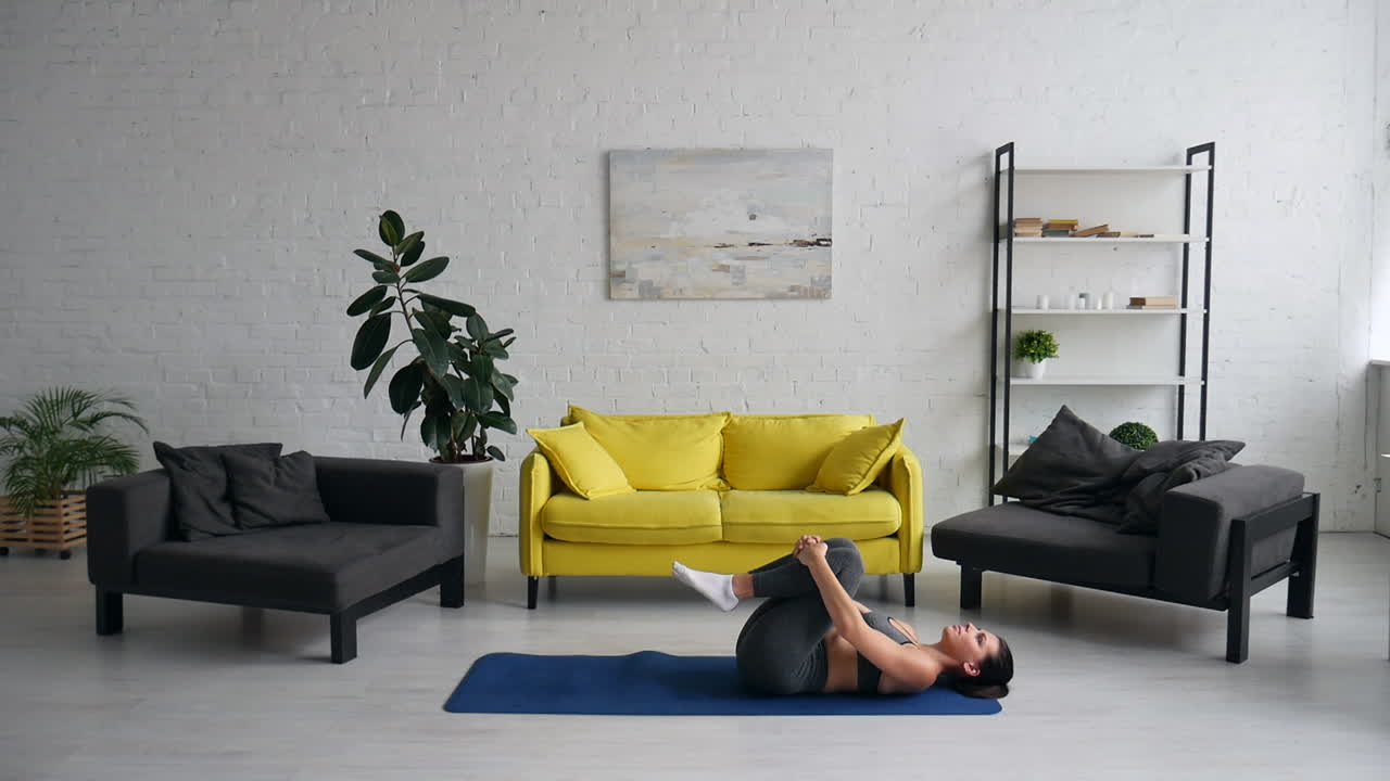 mujer haciendo ejercicios de yoga en casa