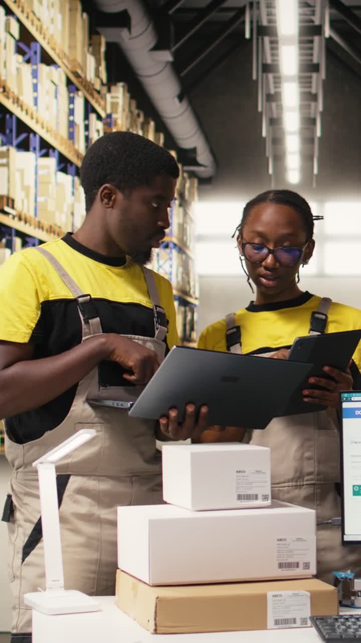 Vertical Video Warehouse staff overseeing parcels tracking info on laptop and tablet
