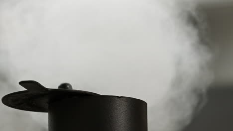 Macro-close-up-of-smoke-rising-from-offset-BBQ-smoker-chimney-in-slow-motion