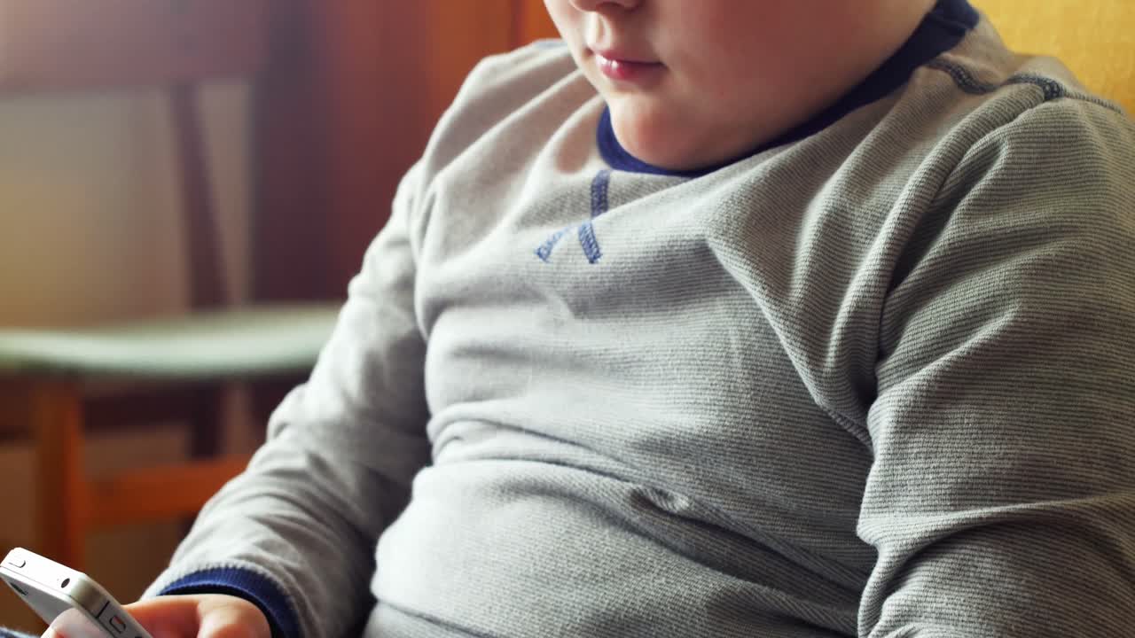 Boy using mobile phone in living room 4k