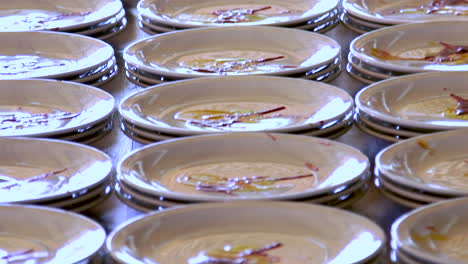 dishes with plating sauce being prepared for a banquet, medium shot tilt down