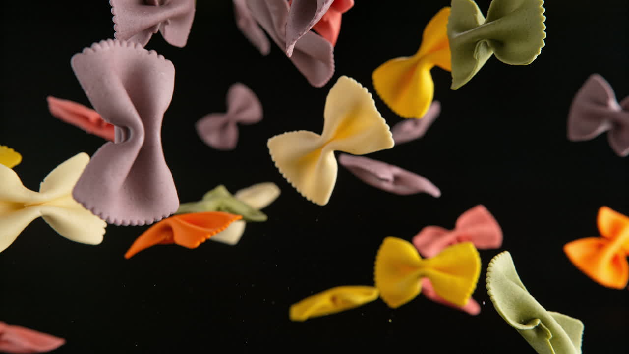 Colorful Farfalle Pasta Flying On The Black Background In Slow Motion And Macro