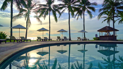 Sombrilla-Y-Silla-Alrededor-De-La-Piscina-En-El-Hotel-Resort-Para-Viajes-De-Placer-Y-Vacaciones-Cerca-De-La-Playa-Del-Océano-Al-Atardecer-O-Al-Amanecer