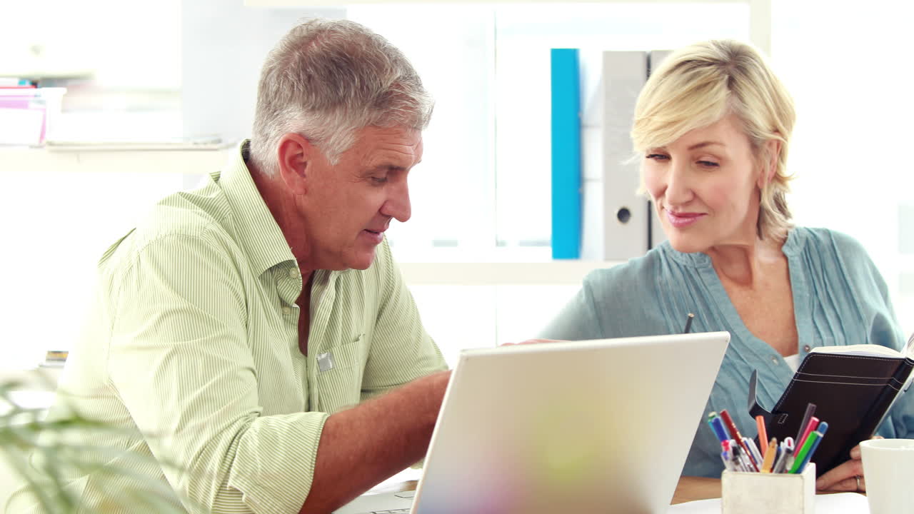  Smiling designer team using laptop