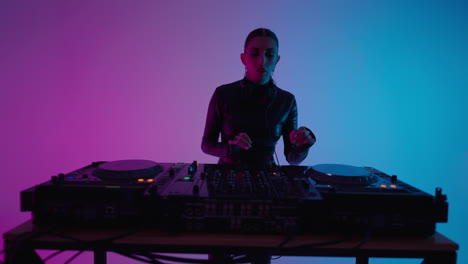 woman dj mixing music in a studio with neon lights