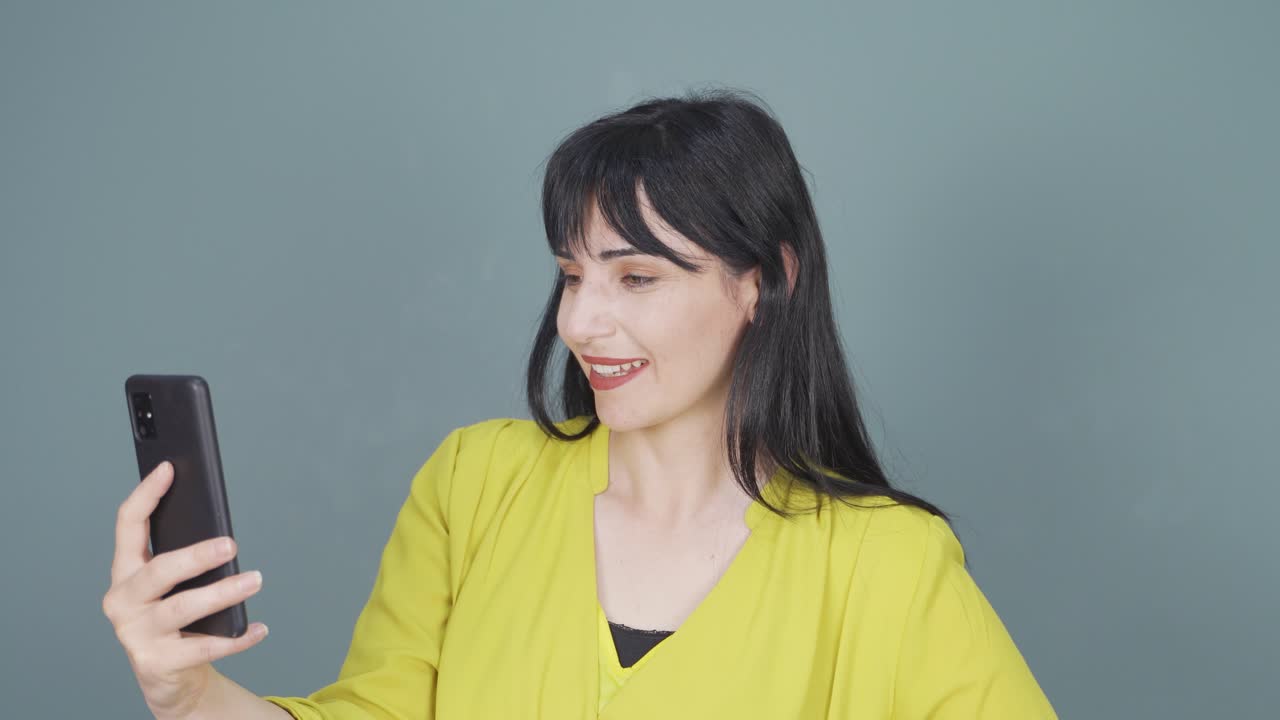 여성이 전화로 비디오 통화를 하고 있습니다.