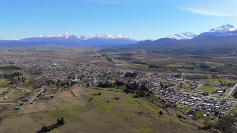 establishing drone shot of trevelin with snowy mountains in patagonia, argentina
