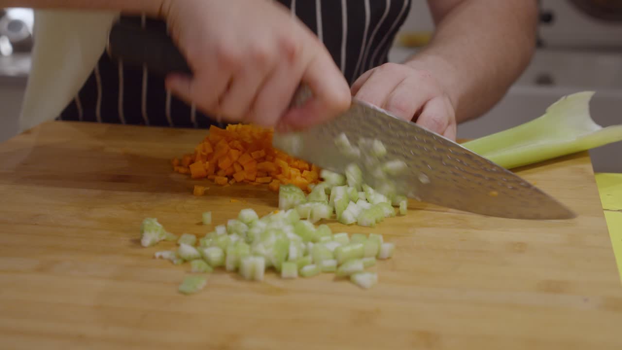 Chef cuts celery vegetable on wooden cut board