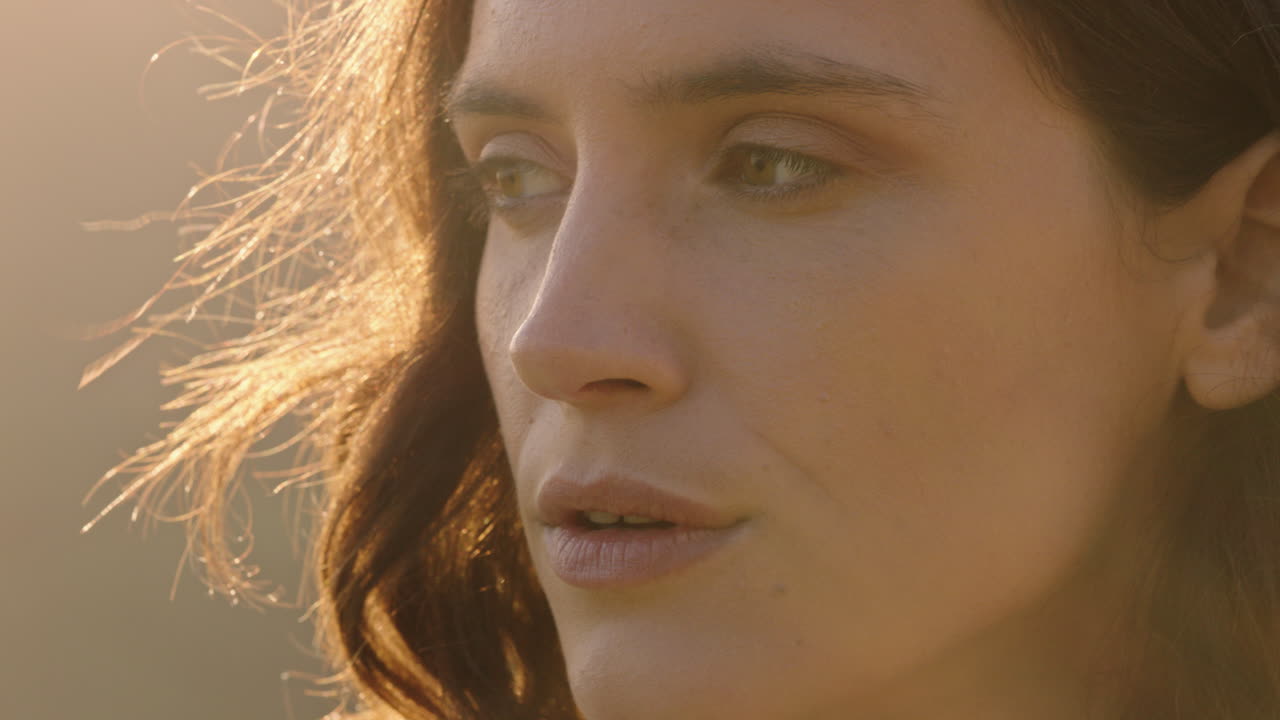 близкий портрет красивой женщины, наслаждающейся мирным закатом солнца, исследующей духовность, глядя вверх, молясь, размышляя о путешествии с ветром, дующими волосами