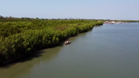 Canoe-Sails-on-River-Gambia-near-Stala-Adventures,-Kartong---The-Gambia,-aerial-drone-Panoramic-Shot-of-West-African-Natural-Landscape