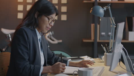 自宅のオフィスでコンピューターで働く女性