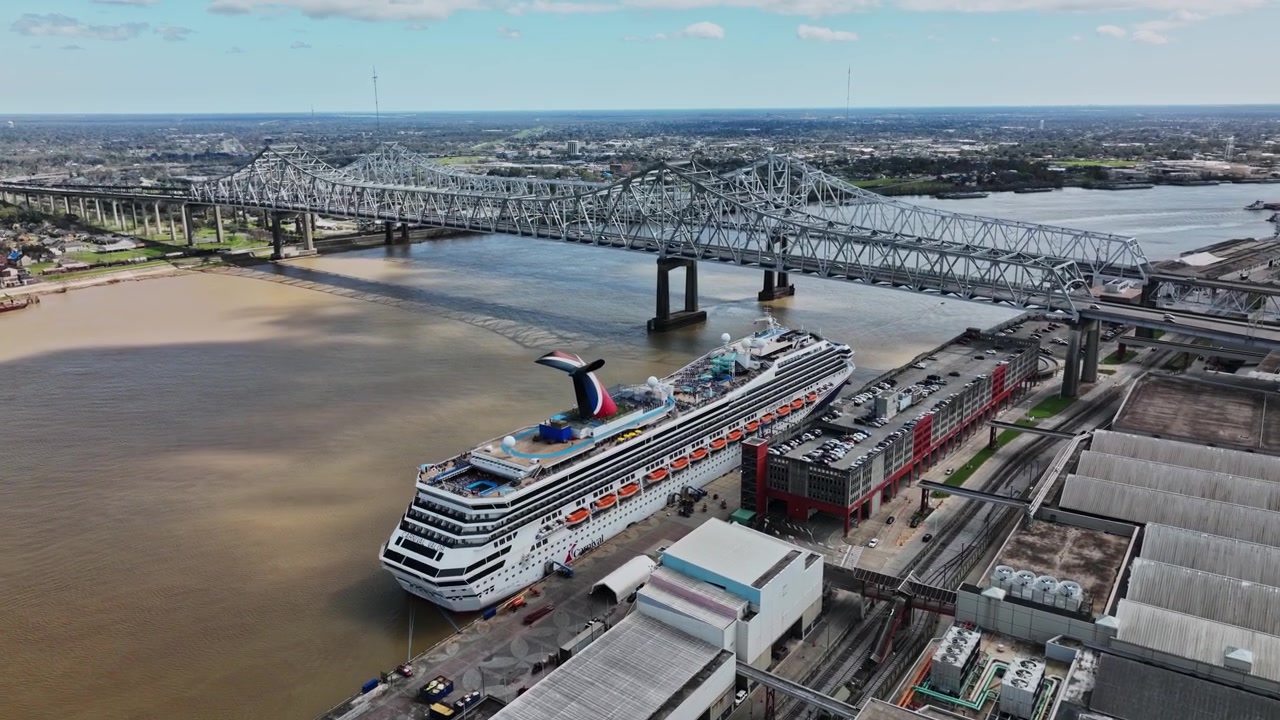 Ein Kreuzfahrtschiff liegt im Hafen neben einer Brücke