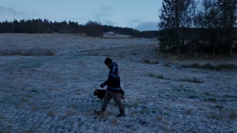 Indre-Fosen,-Trondelag-County,-Norway---In-November,-a-Man-Takes-a-Stroll-with-His-Dog-Through-the-Farm---Tracking-Shot