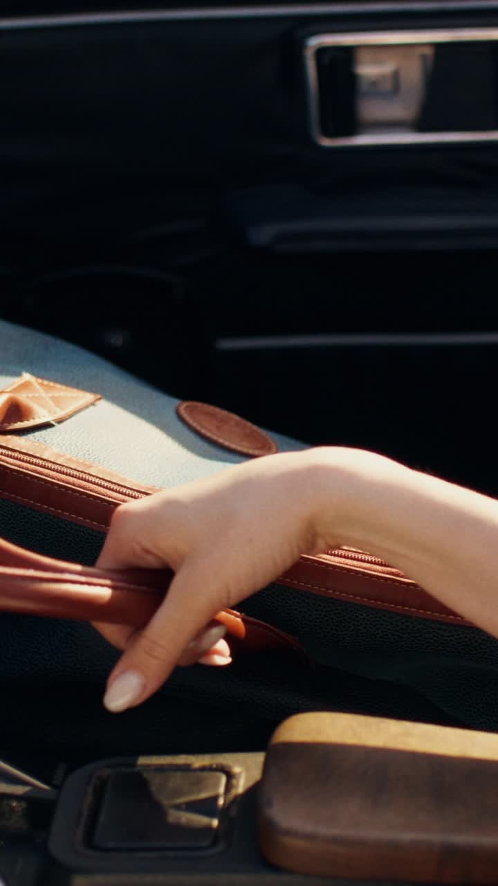 Woman in vintage car with travel bag