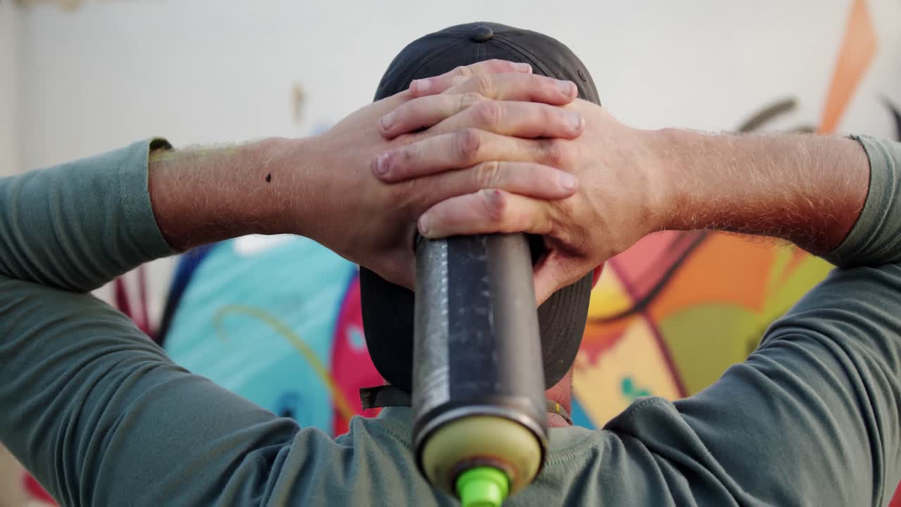 artista de graffiti con las manos detrás de la cabeza 4k