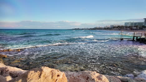 Rocky-coastline-with-calm-waves-under-a-clear-sky