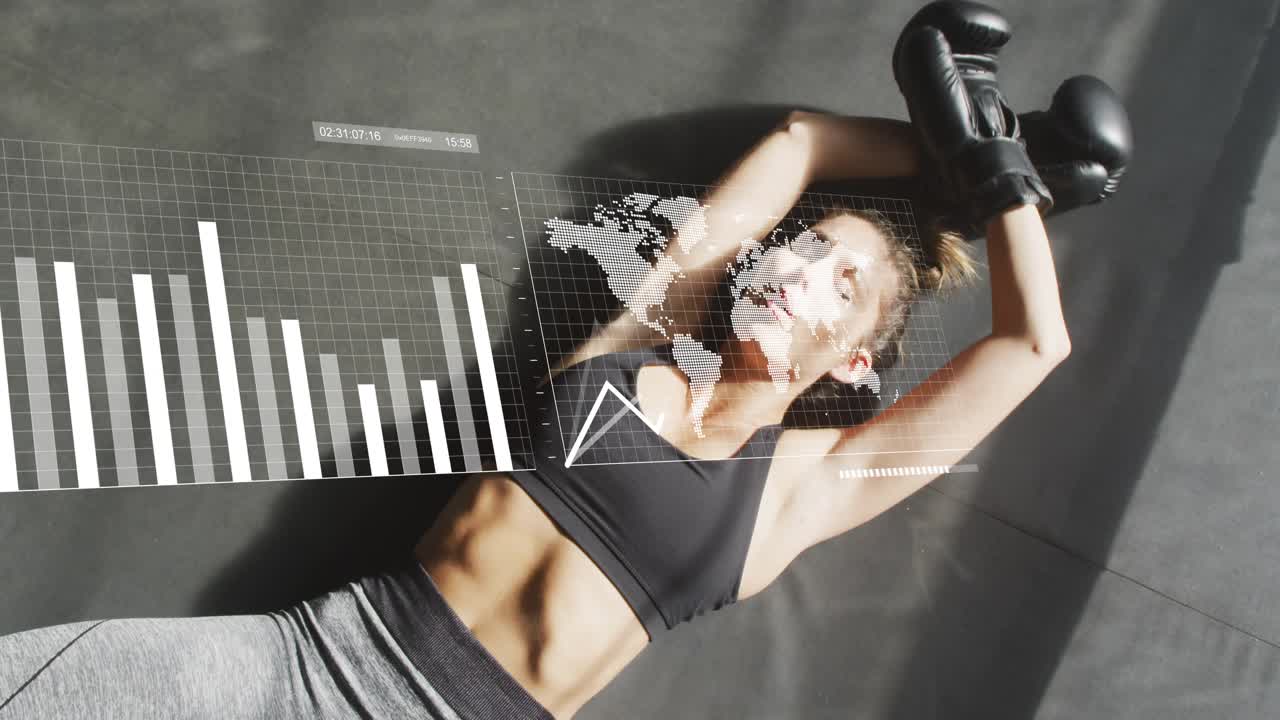 Female athlete lying on mat, raising gloved hands as HUD charts sliding, tracking recovery metrics