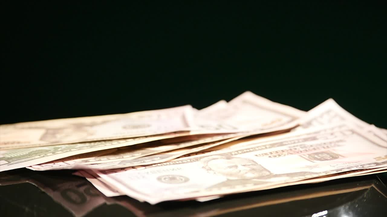 Springendes Geld auf bewegtem Subwoofer vor schwarzem Hintergrund